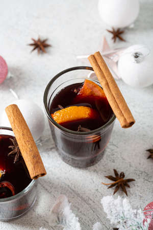 Winter spice beverages with orange and cinnamon on light surfaceの写真素材