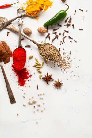 Spice and condiment on spoons and white surface cooking conceptの写真素材
