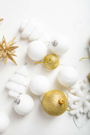 Overhead view of golden and white Christmas decorations on light surfaceの写真素材