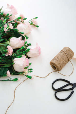Pink roses on white surface holiday conceptの写真素材