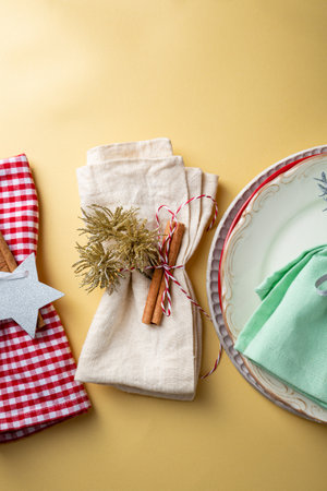 Christmas plate setting on golden surface copy space top view napkin cinnamon sticksの写真素材