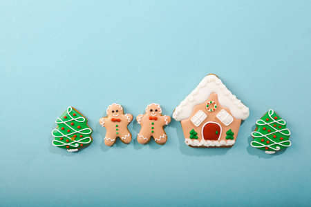 Christmas concept flat lay with gingerbread men and house on blue surfaceの写真素材