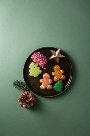 Overhead view of sweet Christmas gift with cookies and holiday decorations on dark plateの写真素材