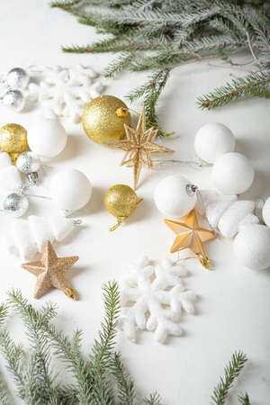 Composition with white and golden Christmas decorations and green branchの写真素材