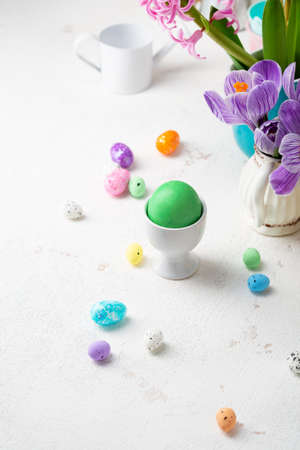 One green Easter eggs and decoration eggs on light tableの写真素材