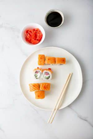 Salmon and tuna rolls on white plate top viewの写真素材