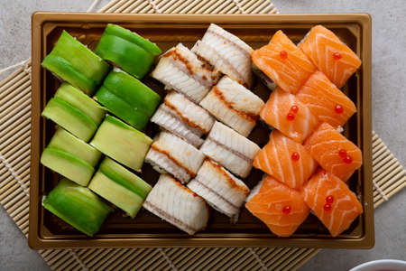 Overhead view of sushi rolls in take away trayの写真素材