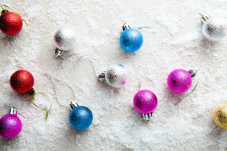 Holiday concept color Christmas balls on snow top viewの写真素材