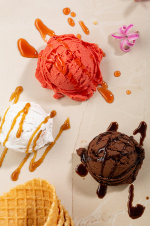 Chocolate fruit and vanilla ice cream scoops with caramel topping and waferstickの写真素材