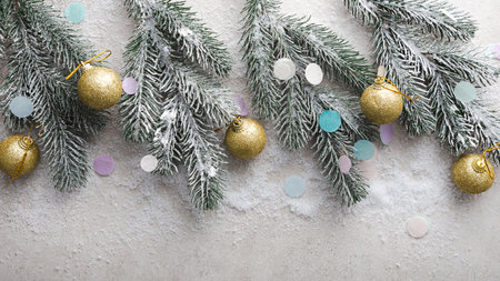Holiday concept Christmas decorations balls on snow top view new year green branchesの写真素材
