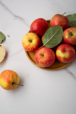 Fresh red and yellow apples on plate healthy food on light surfaceの写真素材