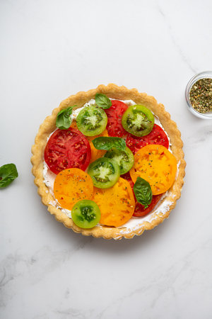 Top view of savory pie with cheese and tomatoes slice quiche on light surfaceの写真素材