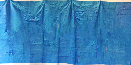 Blue polyethylene on the white wall. Crumpled texture.の写真素材