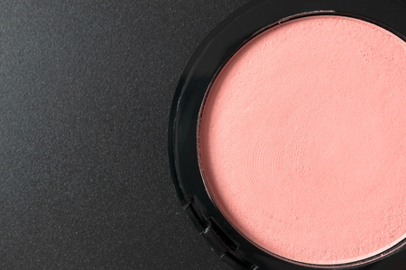 Compact pink blush on black background with copy space, close upの写真素材
