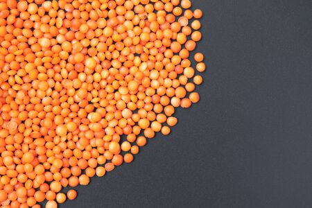 Red lentils on black background with copy space, food textureの写真素材