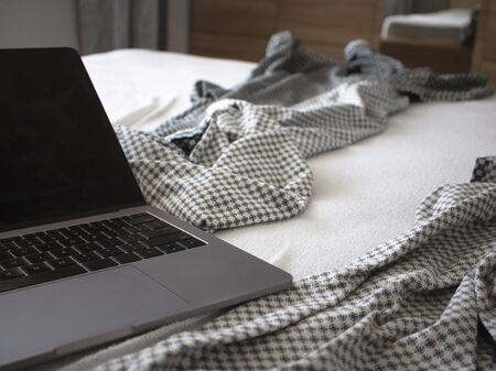 Laptop on the bed. Work at home or dependence on devicesの写真素材