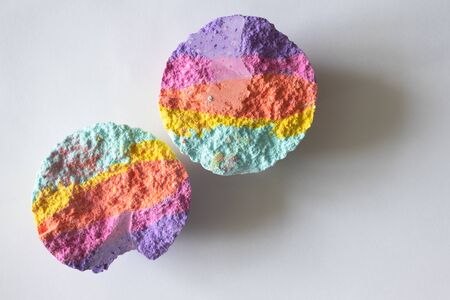 Halves rainbow bath bombs on white background