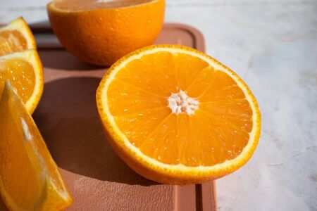Close-up of half orange and orange slices on cutting board. Fresh and juicy fruits for healthy breakfastの写真素材