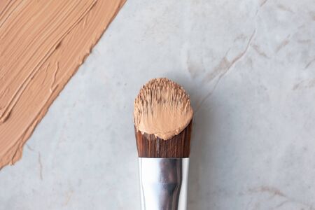 Makeup brush and creamy foundation on luxury marble background, above. Professional cosmetic cover, close-upの写真素材