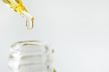 Close-up oil face moisturizer drop in glass bottle on white background with copy space. Skincare beauty productの写真素材