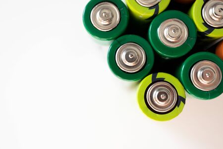 Alkaline batteries with selective focus on white background, top view. Concept recycling and sorting...