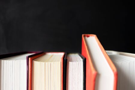 Stack of books with selective focus on black background with copy space. Conceppt choice