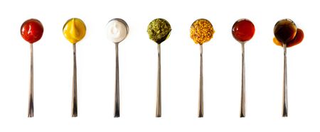 Ketchup, mustard, mayonnaise, basil pesto, sweet chili sauce and teriyaki soy sauce in spoon...