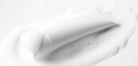 Moisturizer cream, shampoo or facial cleanser in white plastic tube and gentle soap foam with...