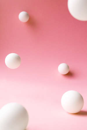 Levitation white abstract spheres on pink background with selective focus, front view. Backdrop...
