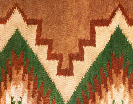 Geometric folk woolen weavers craft rug. Macro tribe textured pattern