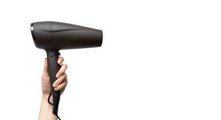Woman hand holding hairdryer isolated on white background with copy space, horizontal. Haircare conceptの写真素材