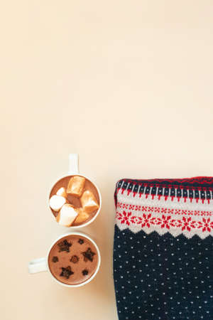 Hot cocoa with marshmallows and cocoa powder decor stars shape in white cups and Xmas sweater on...