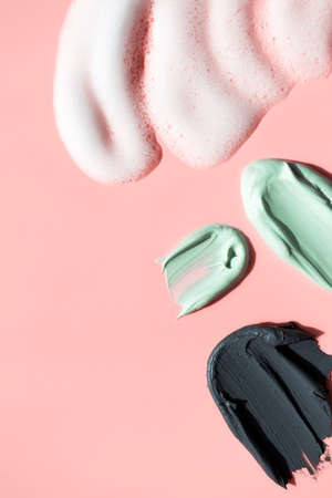 Various body washes cosmetic smudge textures on pink background, vertical. Cosmetic texture black...