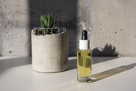 Facial yellow oil serum glass bottle with pipette mockuo and succulent, still lifeの写真素材