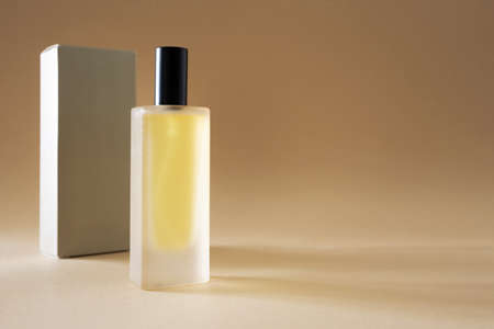 Perfume bottle and wrapping box on beige background with copy spaceの写真素材