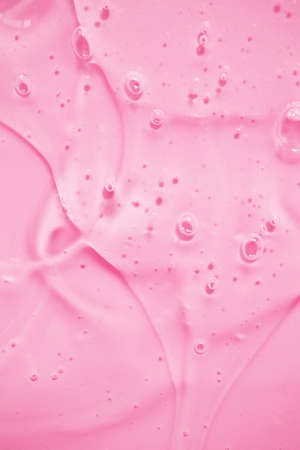 Liquid gel cosmetic smudge with bubbles on pinkの写真素材