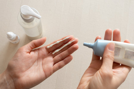 Facial sunscreen moisturizing cream on woman hand. Minimal and clean daily skincare and self-care routine. Concepts of beauty, dermatology, personal hygiene, natural cosmetics, and wellness lifestyleの写真素材