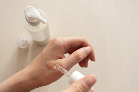 Serum application on hand with dropper, neutral minimal skincare conceptの写真素材