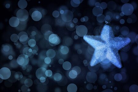 Fabric christmas star on a black background with snowflakes in blue gradient colors.の写真素材