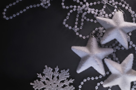 Three white stars, snowflake and crystalline beads on the black background.の写真素材