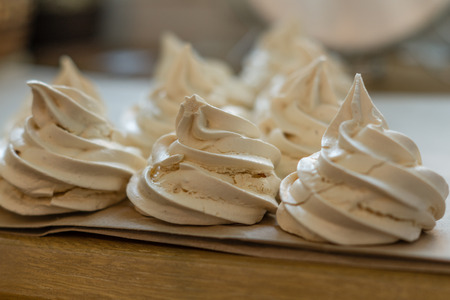 ?reamy meringues on a parchment stays in a line