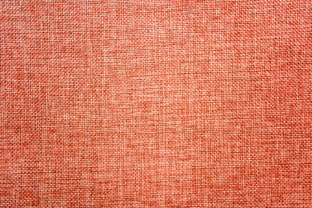 Empty abstract background with natural burlap highly detailed texture. Ecology friendly rough fabric with thin threads colored in blend of bright orange and beige colors. Copy space. View from above.の写真素材