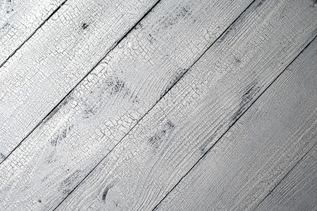 Highly detailed natural wooden planks painted in white color with craquelure effect. Textured white and grey aged background with diagonal layout and copy space. Vintage style. View from above.の写真素材