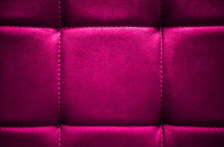 Shiny electric pink artificial textured leather stitched with thread. Close-up of sofa surface. View from directly above. Highly detailed background with copy space divided on few square parts.の写真素材