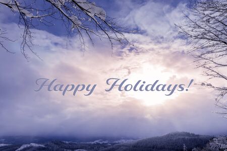 Winter seasonal greeting card with Happy holidays sign. Fantastic winter mountains panorama and sun...