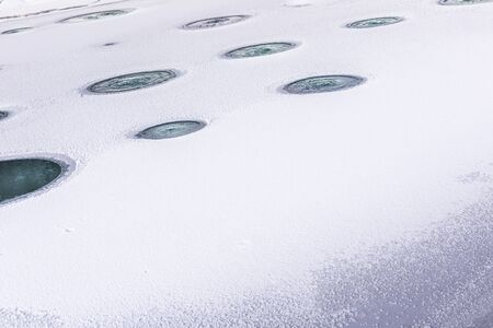Aerated pond with lines of holes made in ice, that is covering fish pond during winter season,...