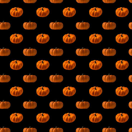 Seamless pattern with side and high angle views of bright orange round textured pumpkins on black...
