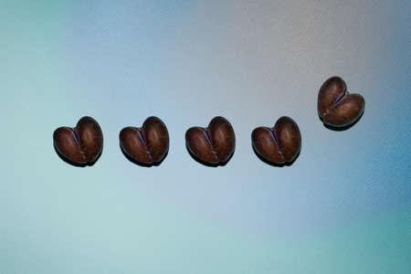 Imperfect row of five ripe brown and blue natural heart shaped plums in centre of multicolored peach, blue and green paper background. Pattern with hard shadows. Copy space. View from directly above.の写真素材