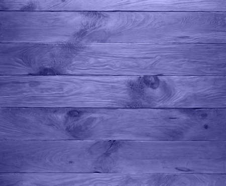 Empty handmade background made of natural wooden planks toned in very peri, color of 2022 year. Surface has textured scratches, spots and stains. Horizontal layout. Copy space.の写真素材