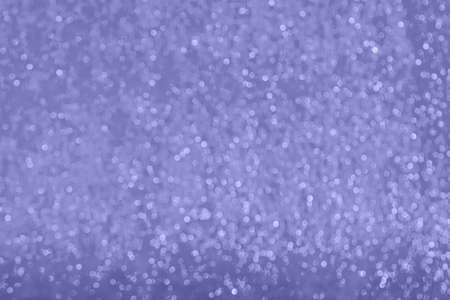 Close-up of defocused surface of shiny metallic wrapping film, toned in very peri, color of year 2022. Large amount of bokeh. Abstract background with copy space. Horizontal orientation.の写真素材